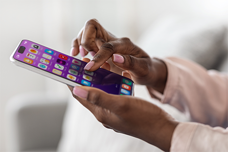 Dark skinned woman's hands using a mobile phone.